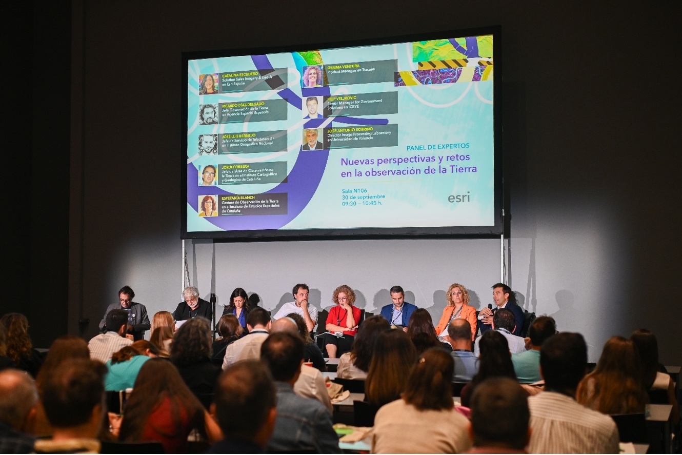 Grup dels ponents i moderadors de la taula rodona, asseguts davant d’un panell de la Conferència Esri España 2026.