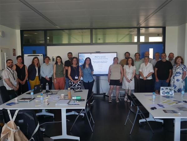 Eighteen participants in the workshop, standing in a workroom